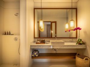 a bathroom with a sink and a mirror at Bumbak Park Villas in Canggu