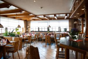 ein Restaurant mit Tischen, Stühlen und Fenstern in der Unterkunft Gasthaus Stroh in Buchholz