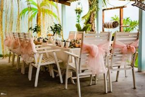 una mesa con sillas blancas y tutuglers rosas en Ky Co Nhon Ly Summer House, en Quy Nhon