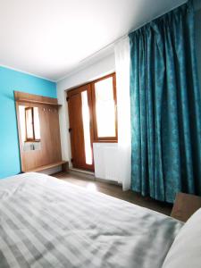 1 dormitorio con 1 cama con paredes y ventanas azules en BBS Residence, en Cluj-Napoca