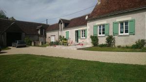 una casa con finestre con persiane verdi e un vialetto di Longère du sud Touraine au Coeur du Val de Loire a Saint-Jean-Saint-Germain