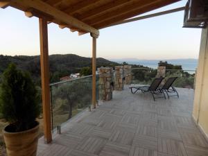 a balcony with chairs and a view of the ocean at Melina Skiathos in Kolios