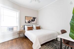 a white bedroom with a bed and a window at Lively 2BR Apt in Lincoln Square - Eastwood 47-1 in Chicago