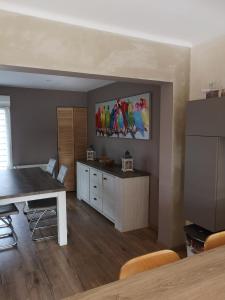 une cuisine avec une table à manger et un tableau mural. dans l'établissement Duplex cozy, à Montigny-lès-Metz