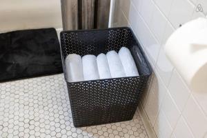 a black container filled with white toilet paper in a bathroom at Lively 2BR Apt in Lincoln Square - Eastwood 47-1 in Chicago +32 photos
