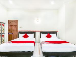 two beds sitting next to each other in a room at D' Anjung Inn in Tangkak
