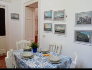 uma mesa de jantar com uma toalha de mesa azul e branca em Da Rossana em Procida