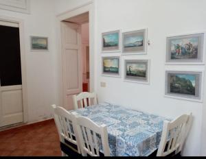 uma sala de jantar com uma mesa e algumas imagens na parede em Da Rossana em Procida