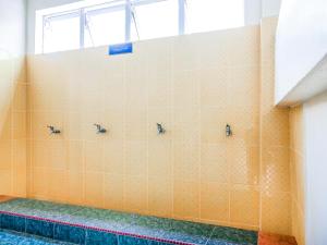 a tiled bathroom with three faucets on the wall at D' Anjung Inn in Tangkak