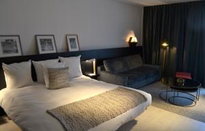 a bedroom with a large bed and a couch at OFF in Wavre
