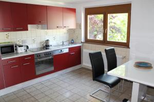 a kitchen with red cabinets and a table with chairs at Nahe am See in Überlingen