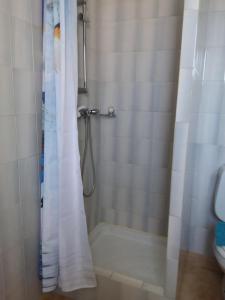 a shower with a white shower curtain in a bathroom at Chambre d hôtes chez raymonde et sandrine in Luri