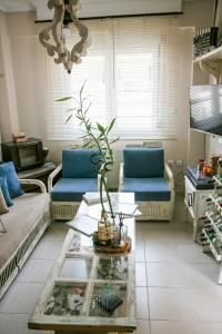 uma sala de estar com sofás azuis e uma mesa de vidro em 3min from Central Station em Tessalônica