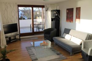 a living room with a couch and a tv at Nahe am See in Überlingen