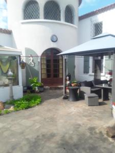 a white house with a patio and a brown door at Touch of Spain in Rural France in Darnac