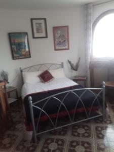 a bedroom with a bed in a room with a window at Touch of Spain in Rural France in Darnac