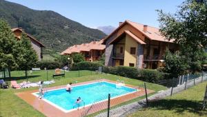 un gruppo di persone in una piscina di fronte a una casa di Chalet turístico La Jenduda a Ojedo