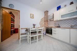 a kitchen with white cabinets and a table and chairs at Apartman Marcela in Rab