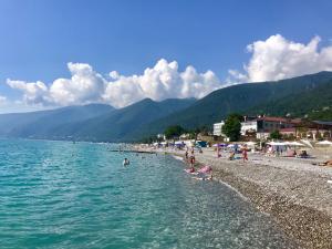 een groep mensen op een strand bij het water bij Pod evkaliptom Apartment in Gagra