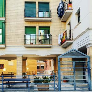 a building with two benches in front of it at Residencial Oscense in Huesca