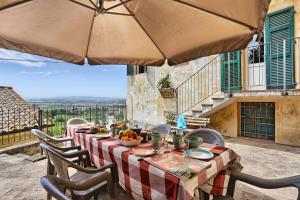 a table with chairs and an umbrella on a patio at La Canonica di Alica in Palaia