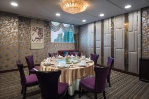 a dining room with a table and purple chairs at The Berkeley Hotel Pratunam in Bangkok