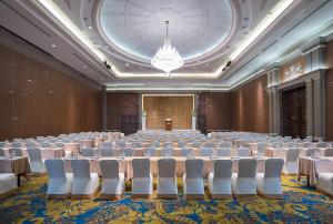 a large room with tables and chairs and a chandelier at The Berkeley Hotel Pratunam in Bangkok