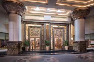 a lobby with columns and doors with potted plants at The Berkeley Hotel Pratunam in Bangkok