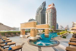 a swimming pool in a city with tall buildings at The Berkeley Hotel Pratunam in Bangkok