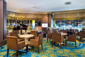 a restaurant with tables and chairs and a piano at The Berkeley Hotel Pratunam in Bangkok
