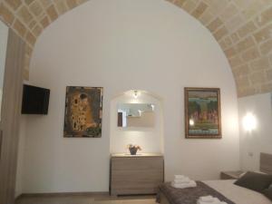 a room with a bed and a mirror and a dresser at Domus del Borgo Antico in Ginosa