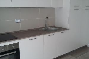 a kitchen with white cabinets and a sink at Chalet La Perla Molveno in Molveno