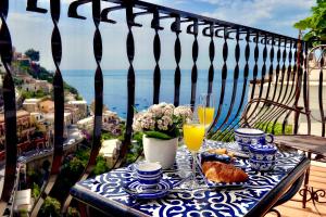 a blue and white table with food and drinks on a balcony at Gema Suites in Positano