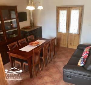 sala de estar con mesa, sillas y sofá en Casa da Barragem en Montalegre