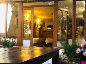 a large wooden table in a room with flowers at Apartmani Lovre Posedarje in Posedarje