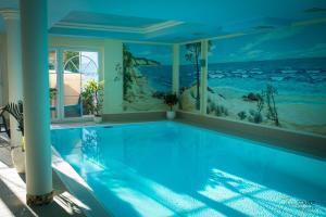 a swimming pool with a mural of the ocean at Hotel Garni Sonnenklahr in Göhren