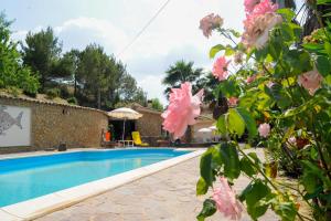 a villa with a swimming pool and flowers at Agriresort Villa Bentivoglio in Piazza Armerina