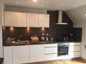 a kitchen with white cabinets and a sink at Self Contained Studio Rumbling Bridge in Kinross