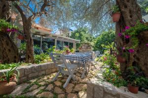 a table and chairs in a garden with flowers at Medin Apartments BluVista in Petrovac na Moru