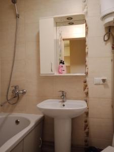 uma casa de banho com um lavatório, um espelho e uma banheira em 2 к квартира между двумя станциями метро Студенческая и Академика Павлова em Kharkov