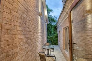a patio with a table and chairs next to a brick wall at Benefit Boutique Hotel in Odesa