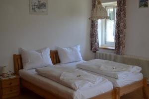 two beds in a bedroom with white sheets and pillows at Gingin- rooms in Hallstatt