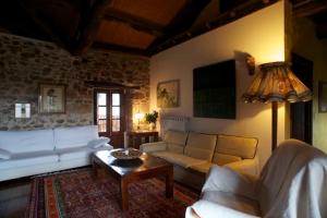 een woonkamer met een bank en een tafel bij El Taller De La Seda in Avedillo de Sanabria
