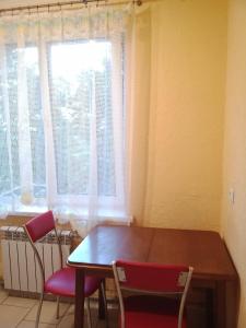 a table and chairs in a room with a window at 2 к квартира между двумя станциями метро Студенческая и Академика Павлова in Kharkiv