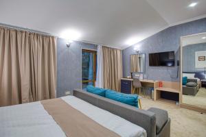 a bedroom with a bed and a desk and a television at Benefit Boutique Hotel in Odesa