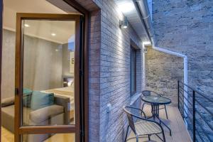 a room with a balcony with a table and chairs at Benefit Boutique Hotel in Odesa