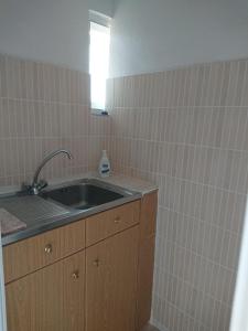 cocina con fregadero y pared de azulejos en Katerina's Apartment, en Plomari