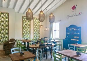 un restaurant avec des tables, des chaises et des fenêtres dans l'établissement Vacanze Glamping Boutique, à San Felice del Benaco