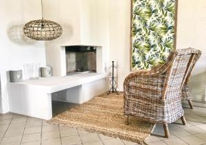a living room with a wicker chair and a fireplace at Vacanze Glamping Boutique in San Felice del Benaco +24 photos
