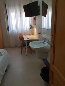 y baño con lavabo, aseo y mesa. en Residencial Oscense en Huesca